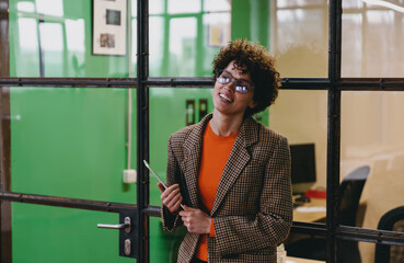 Fototapeta premium Cheerful woman with tablet standing and smiling in office