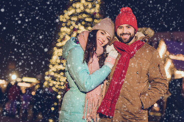 Photo of cute millennial couple hug wear cap jacket scarf gloves on christmas season time