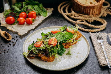 Crispy chicken cutlets topped with fresh greens, cherry tomatoes, and Parmesan