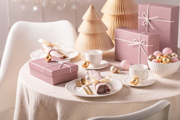 Contemporary Christmas tableware for two surrounded by baubles and decorations.