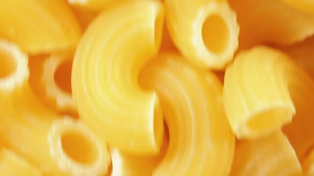 Uncooked Chifferi Rigati Pasta - Top View, Close-Up. Fat and Unhealthy Food. Classic Dry Macaroni, Moving Downward Background. Italian Culture and Cuisine. Raw Golden Pasta Texture in Move