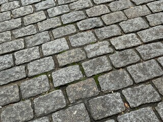 Full frame background of damp drying grey cobblestones
