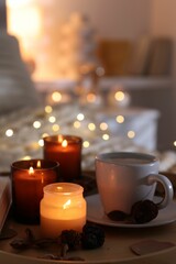 Burning candles, lights, coffee and decor on bed indoors, closeup. Autumn atmosphere