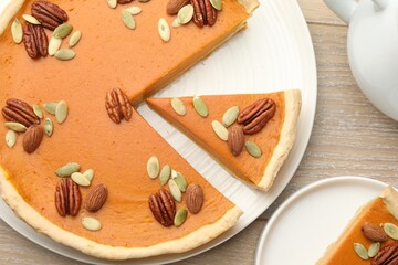 Tasty homemade pumpkin pie served on wooden table, top view