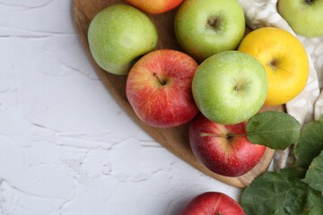 Different whole ripe apples on white table, flat lay. Space for text