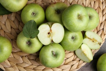 Whole and cut green apples on table, flat lay