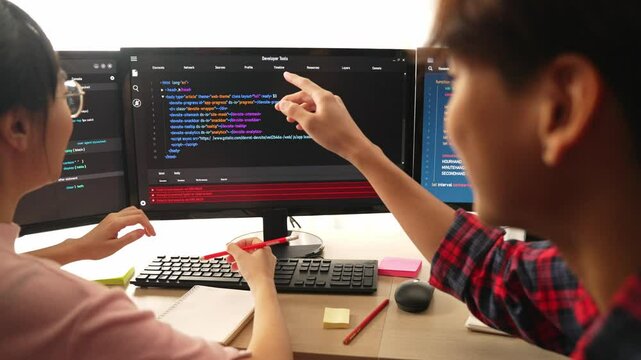 Slow motion back end software developer engineer for computer programming working together on debugging writing computing code, solving complex algorithms display on monitor in office. Burgeoning