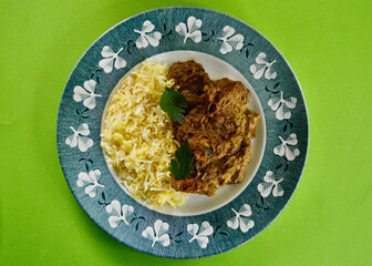 Chicken Mughlai with saffron rice on a plate.