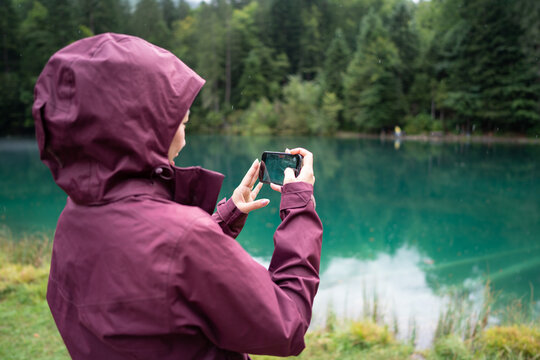 Tourist capturing the serene Blausee lake in Switzerland