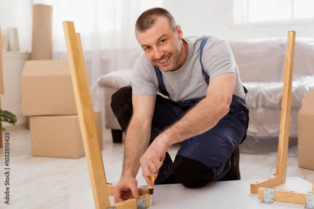 Poster happy repairman assembling furniture installing table after transportation in new home, smiling to c