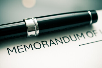 Elegant Black Pen Resting on Memorandum of Understanding Document: A Symbol of Contractual Agreements, Professionalism, and Written Communication in Business Transactions