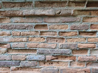 The old brick walls of the ancient site are damaged and broken.