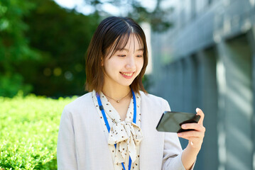 スマートフォンを手にする若いビジネスウーマン
