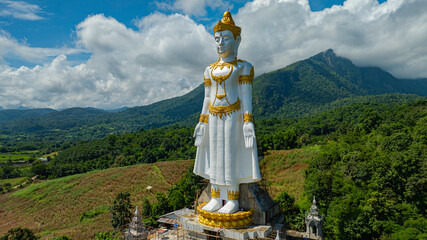Big Buddha Brahma Panyo standing tall in front of Doi Luang mountain, Chiang Mai symbolizing peace...