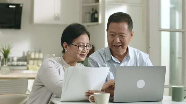 senior asian couple making family financial plan using laptop computer at home
