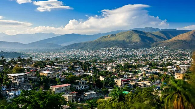 A view of Port-au-Prince, Haiti from the hills, with a clear blue sky and fluffy clouds