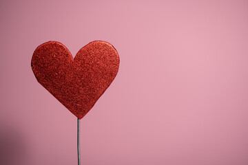 un corazón rojo con fondo rosa con espacio para texto