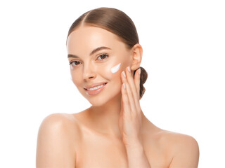 Close-up portrait of young beautiful woman with face cream applied on cheekbones and glowing skin