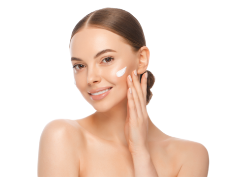 Close-up portrait of young beautiful woman with face cream applied on cheekbones and glowing skin