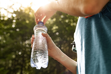 person holding water bottle, drinking water, body care health concept