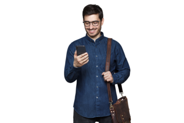 Smiling businessman in glasses and denim shirt standing with phone in hand and bag on shoulder
