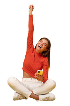 Winner. Excited happy woman sitting on floor with phone, shouting yes