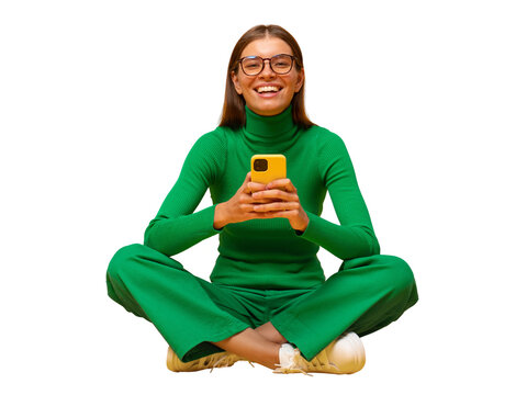 Laughing woman sitting on floor browsing social media posts on phone