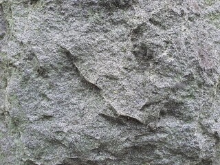 Photo of a brick wall with mold marks, black marks, and a rough surface.