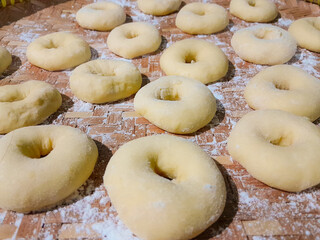 Raw donut dough that has risen and not been fried with a sprinkling of wheat flour on top, homemade...