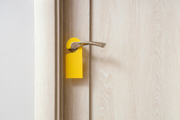 Wooden door with hanger in hotel room, closeup
