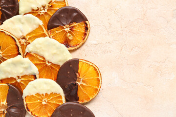 Chocolate dipped dried orange slices on beige background