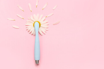 Composition with vibrator and chamomile flower on pink background