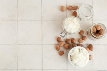 Composition with shea butter and nuts on light tile background