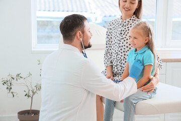 Fototapeta premium Male endocrinologist with stethoscope listening to little girl and her mother in clinic