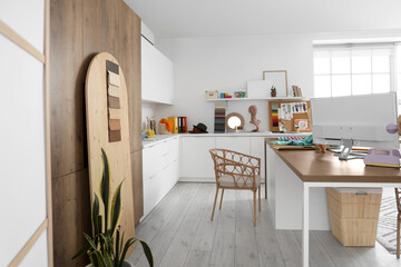 Interior of fashion designer's studio with workplace and sewing supplies