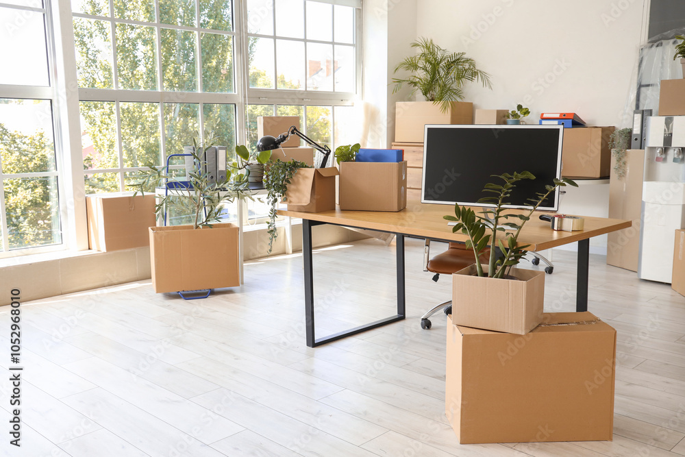 Poster workplace with computer monitor and boxes in office on moving day
