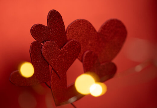 composici&oacute;n de corazones recortados rojos con bokeh de luz c&aacute;lida 