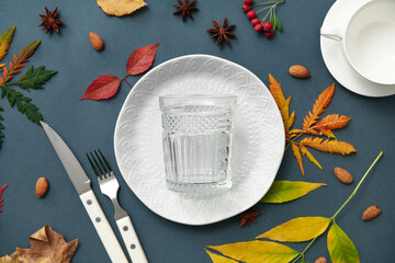 Beautiful table setting with star anise, almond nuts and autumn leaves on dark background