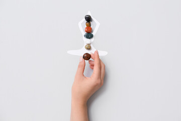 Woman with set of chakra stones on light background