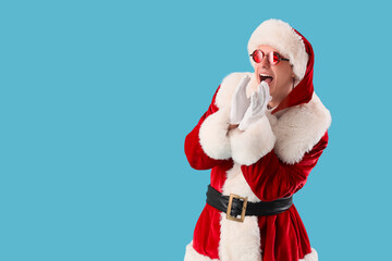 Young Santa Claus shouting on blue background