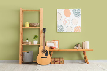 Interior of room with wooden bench, shelf unit and guitar