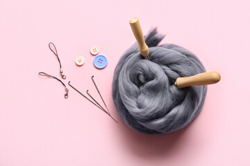 Composition with wool and tools for felting on pink background