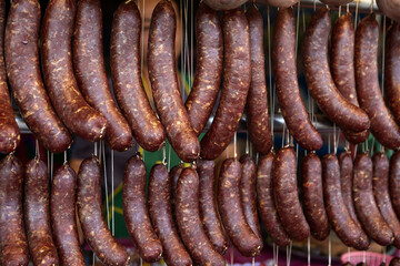 Uncooked Thai I-San sausages hanging for sale at market