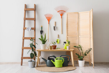 Interior of workshop with gardening tools, table and folding screen