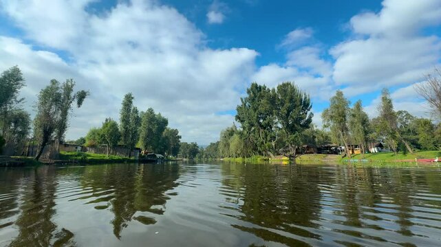 vista de los canales de xochimilco desde una trajinera en la ciudad de m&eacute;xico