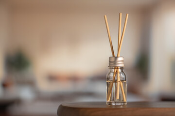 Aromatic air freshener close-up. Aroma sticks in glass bottle on table in room, home comfort concept, high resolution.