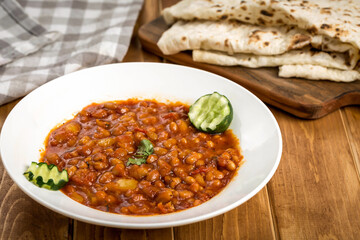 Spicy Red beans with pita bread served in plate isolate on wooden table side view of arabic food