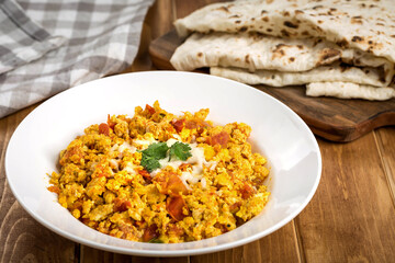 Scrambled Eggs with Pita Bread served in plate isolated on wooden table top view of arabic food