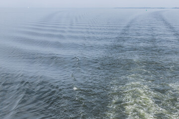 a trace in the sight behind a sailing boat, inland navigation, a trace on the water,