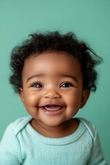 Naklejka premium Close-up of a happy babyâ€™s face, smiling brightly, isolated on a mint green background with room for text,